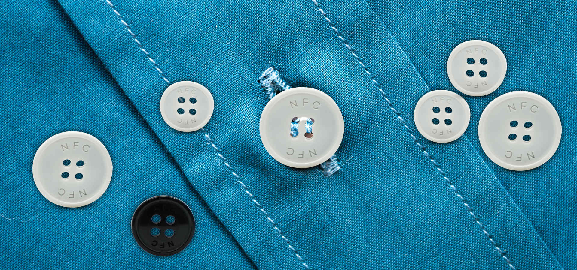NFC buttons sewn on blue shirt