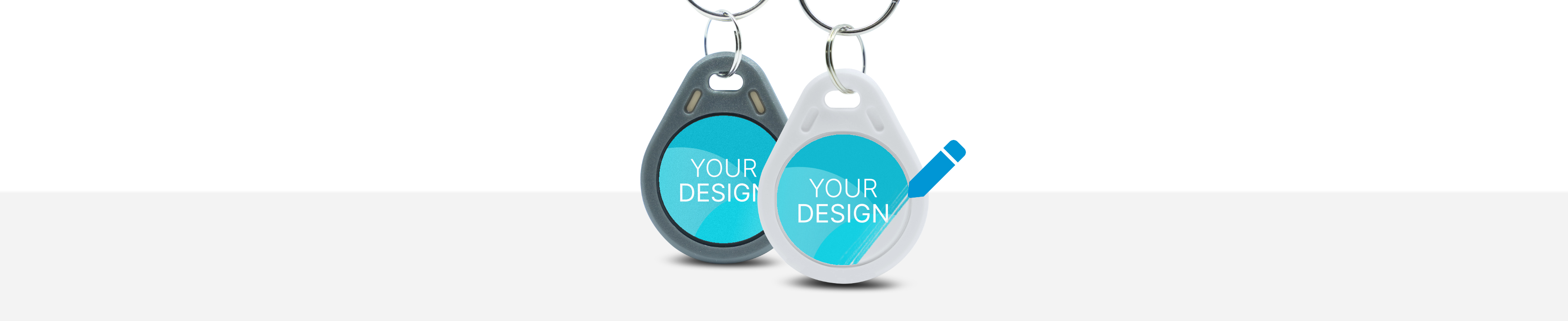 Zwei Schlüsselanhänger mit der Aufschrift "Your Design"