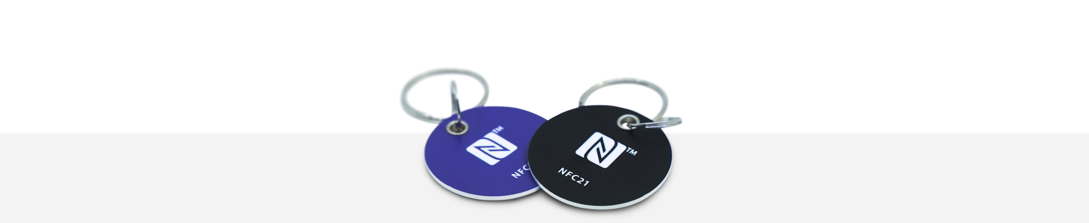 Two round PVC key fobs in black and blue